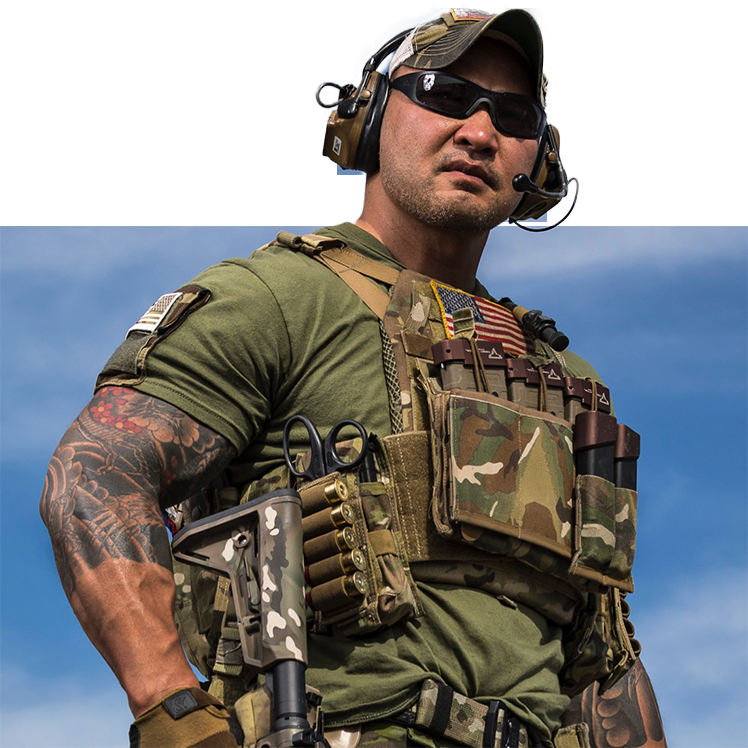 Man in tactical gear with a rifle against a blue sky
